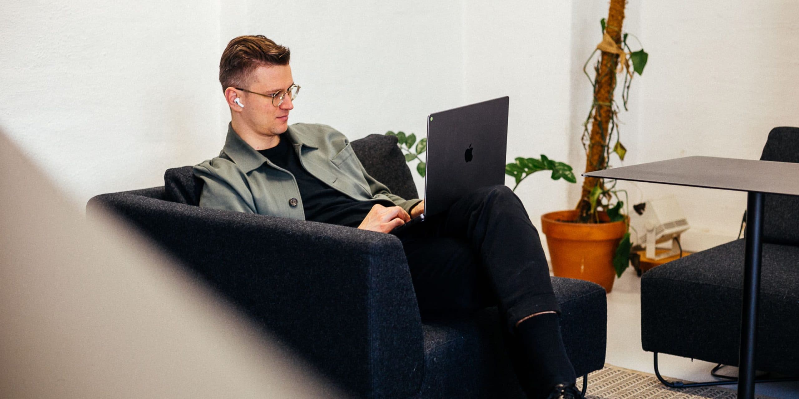 guy sitting on a sofa working on a laptop